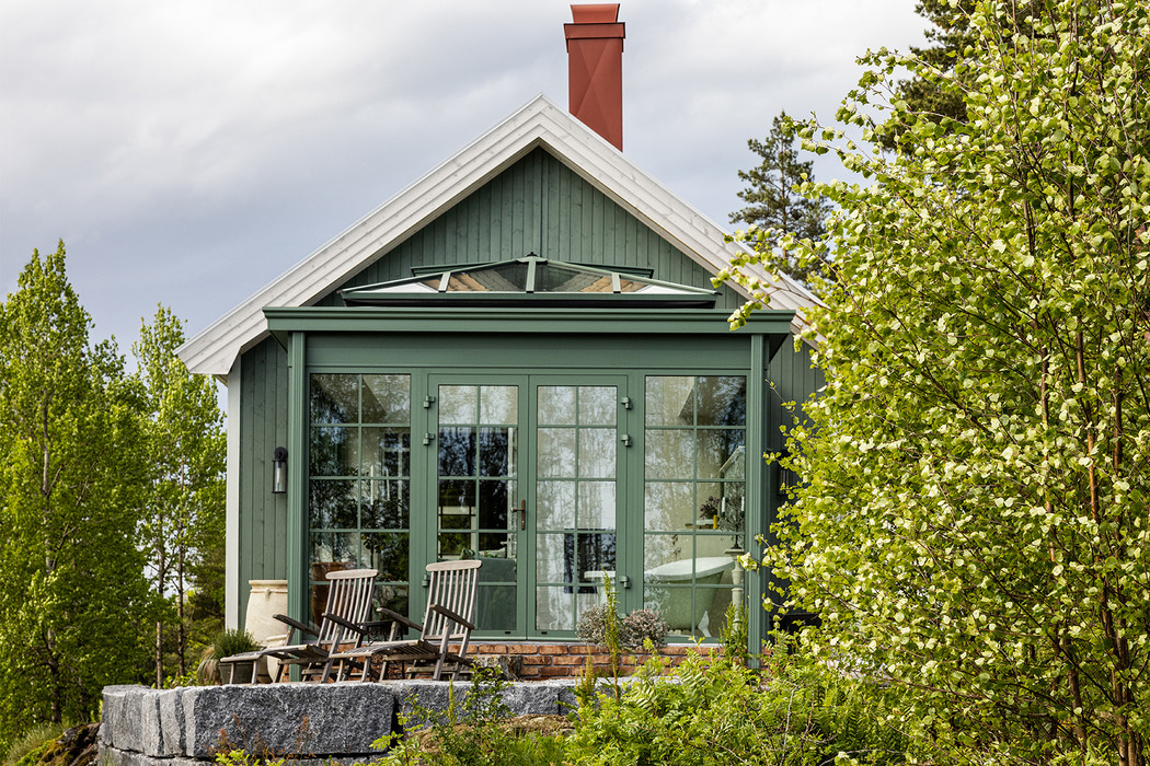 Grønt minihus omgitt av trær.